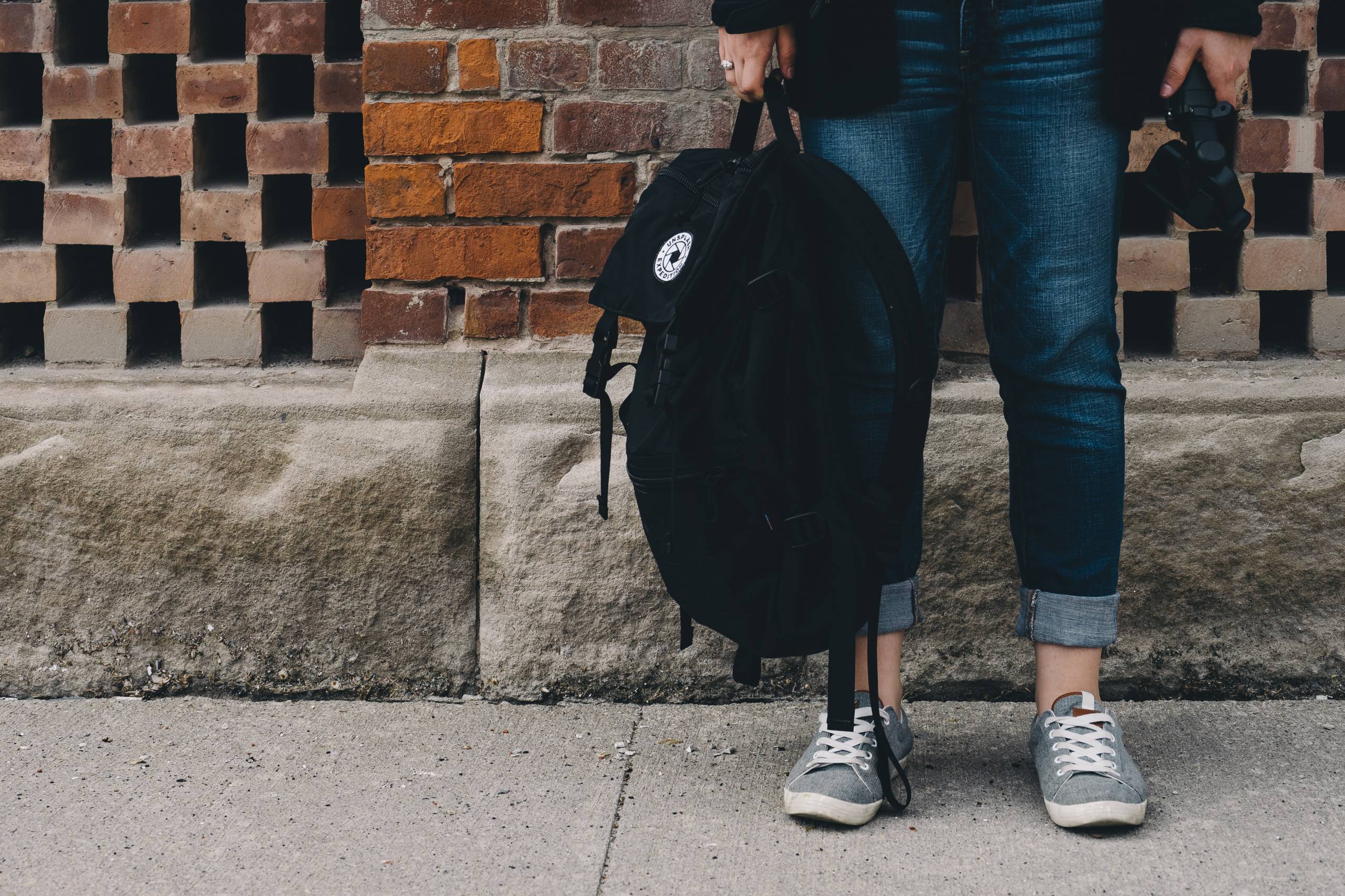 Kids holding a backpack.